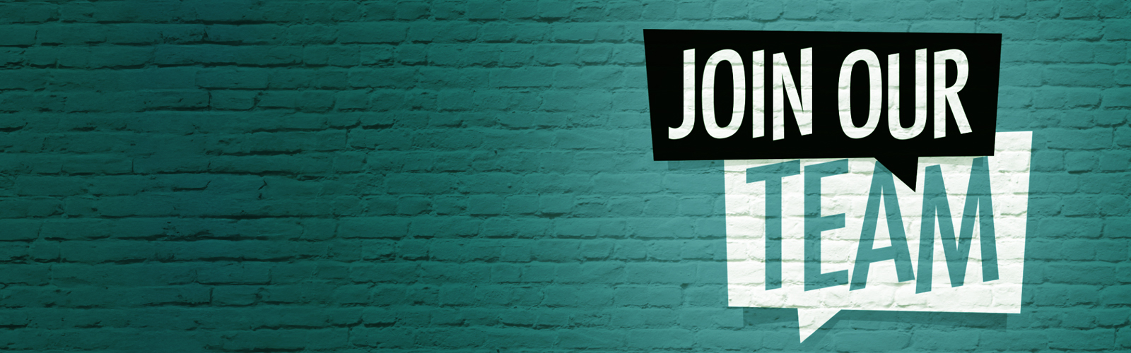 A sign against a brick wall that reads Join Our Team.